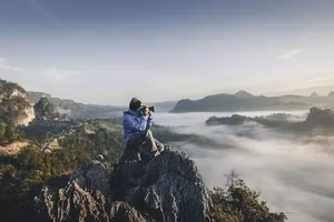 Filmmaker on a mountain top at sunrise