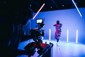 Videographer filming in a neon-lit studio