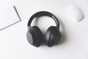 Studio headphones on a desk next to keyboard